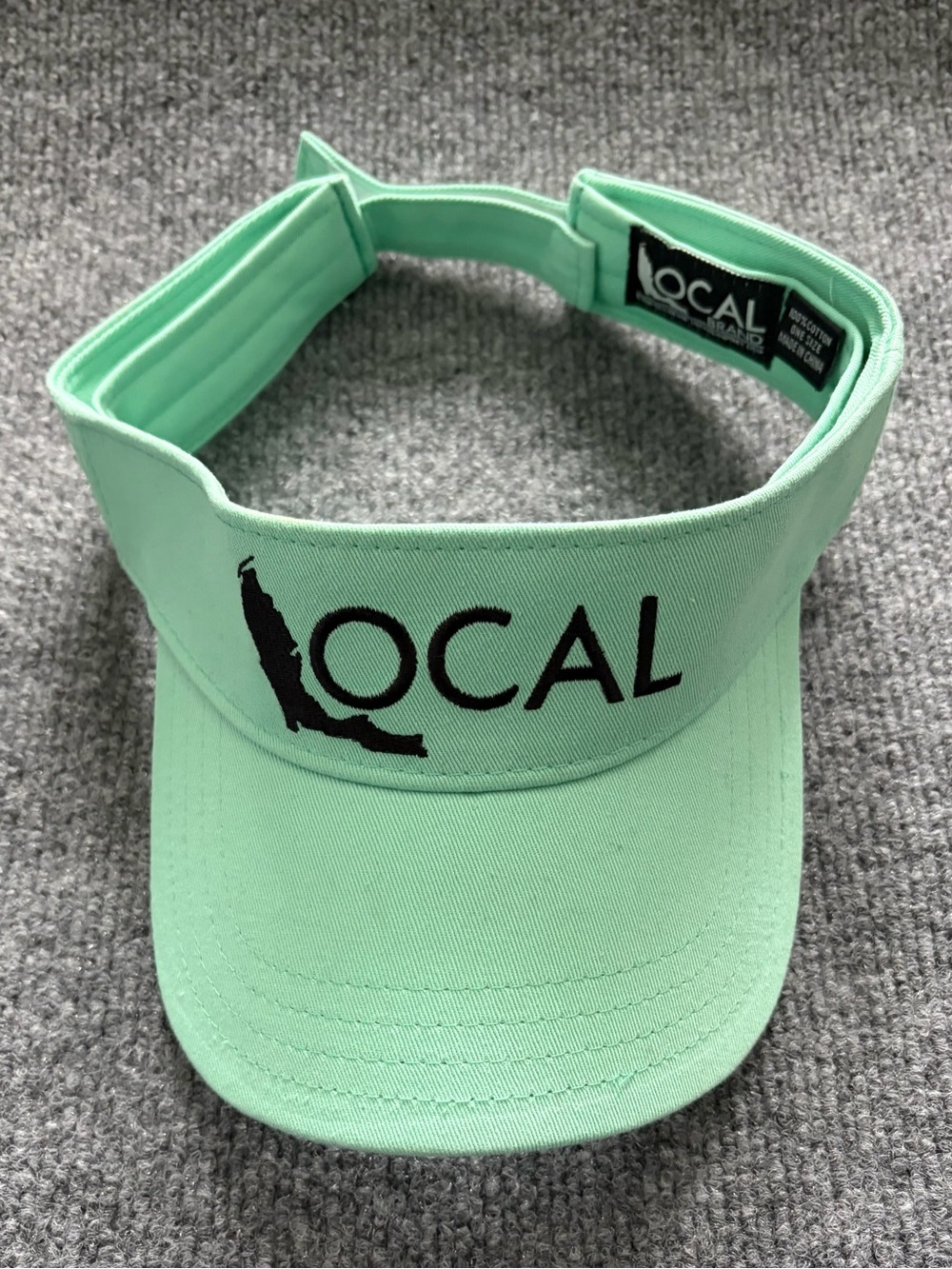 LOCAL Brand adjustable visor in a mint/seafoam green color with a black embroide